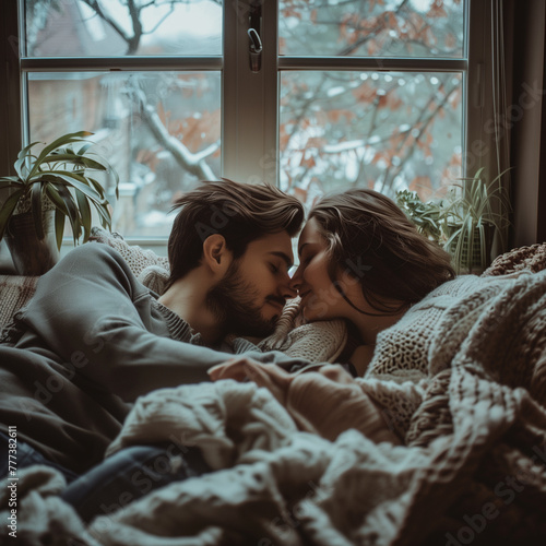 Young couple hugging on the background of a window in a cozy house