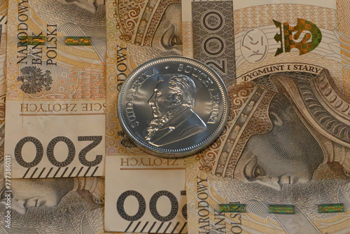 Silver coin, Krugerrand with Polish Zloty notes in background. © PIOTR