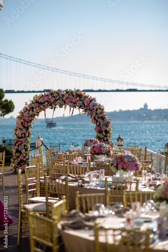 White color wedding table decorated with decorative and elegant for wedding. There are flowers, candles and serving plates on the wedding table.