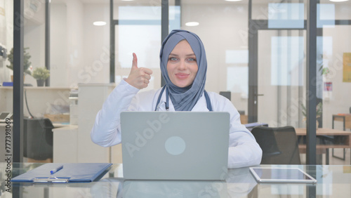 Thumbs Up by Doctor in Hijab while Working on Laptop