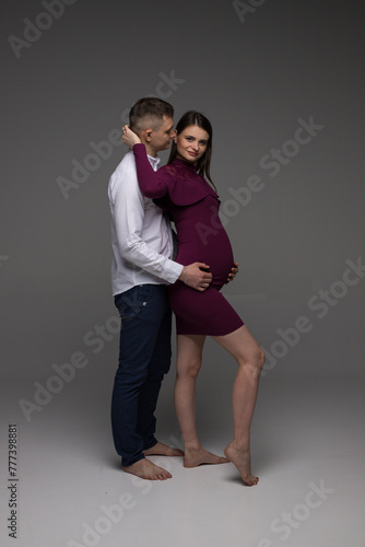 pregnant couple, pregnant couple standing on a grey background