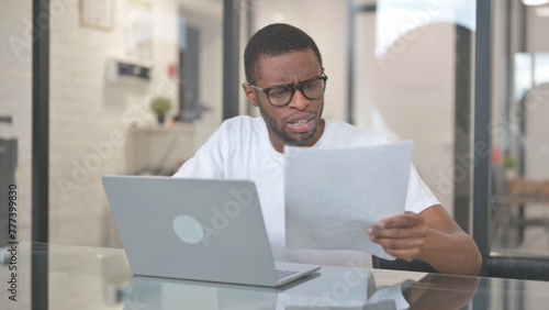 African American Man Upset while Reading Documents