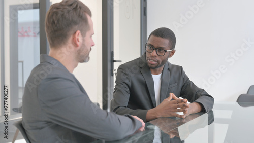 African Man Talking with Teammate in Office