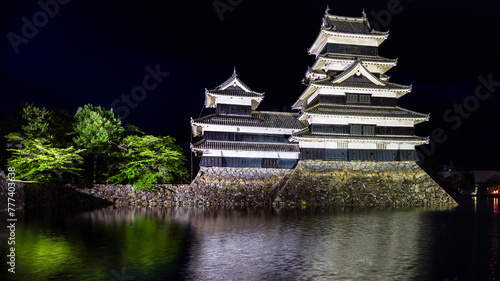 Old Japanese castle at night with reflection in its moat  Matsumoto Castle 