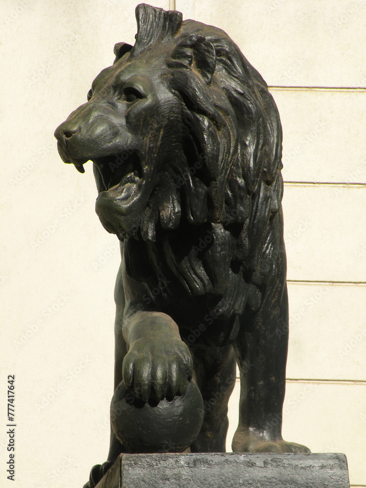 Bronze lion sculpture with paw on sphere