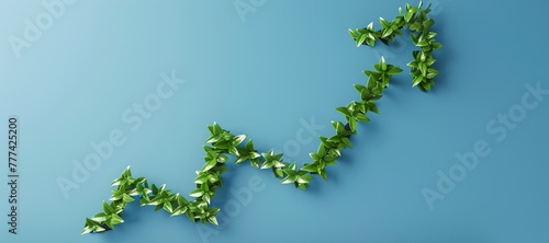 A green vine is growing on a blue wall, creating a line that looks like a graph