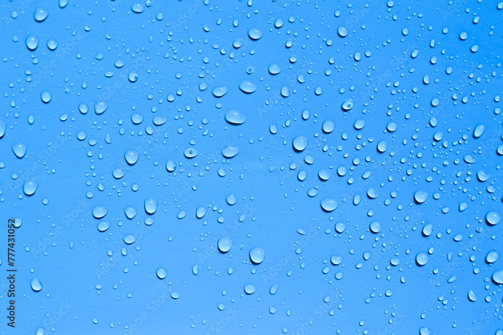 Realistic water drops on blue background or texture