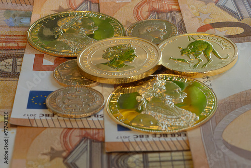 Gold coins with the EURO banknotes in background. © PIOTR