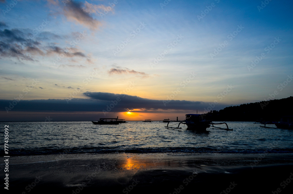 The view of the sunset with a very beautiful sky and boats leaning on Senggigi Beach The view of the sunset with a very beautiful sky and boats leaning on Senggigi Beach