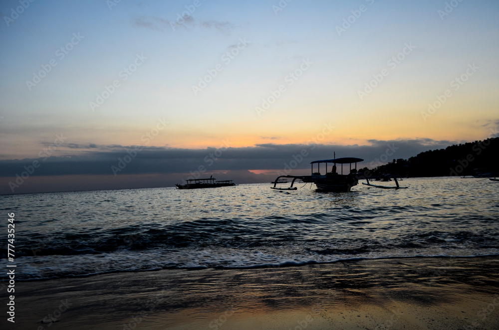 The view of the sunset with a very beautiful sky and boats leaning on Senggigi Beach The view of the sunset with a very beautiful sky and boats leaning on Senggigi Beach