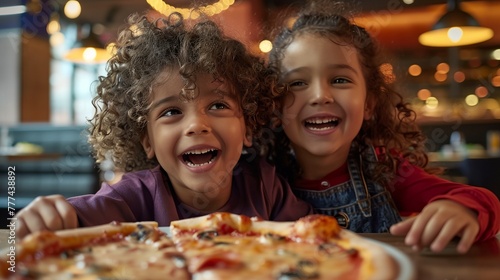 two children sitting at a table with a pizza in front of them