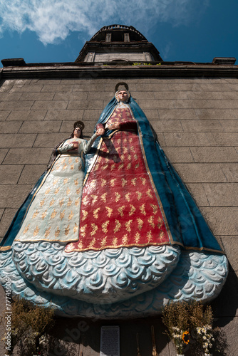 Taguig, Metro Manila, Philippines - Mar 29, 2024: A statue of Saint Anne and Mary on the facade of the belfry of The Saint Anne Parish Church. photo