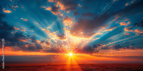 A beautiful sunrise with the sun shining through the clouds   rays of golden light across the blue  sky. sunrise or sunset nature background. banner