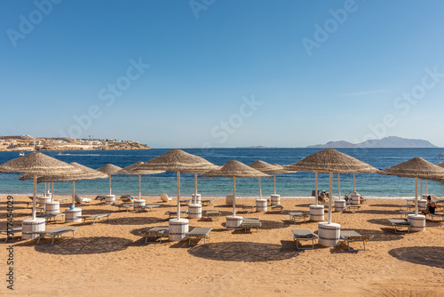 Chairs under umbrellas on tropical beach. Summer vacation concept.