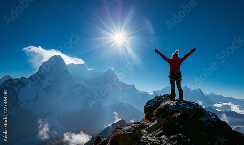 Silhouette of a woman with arms raised on top of a mountain 