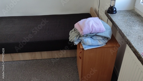 Unfolded bed in a student dormitory and dirty bed linen. Changing bed linen