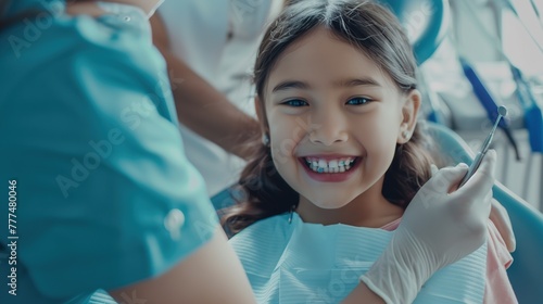A young girl sits confidently in the examination chair  smiling as the dentist gently checks her teeth
