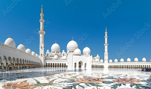 Panoramic view of amazing white Sheikh Zayed Grand Mosque during sunny day against blue sky in Abu Dhabi, United Arab Emirates