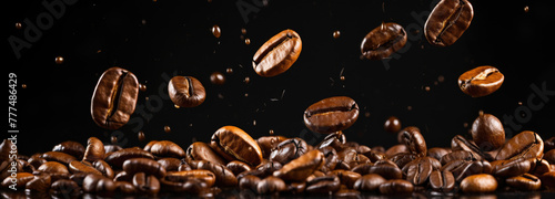 Falling brown roasted coffee beans, isolated on dark black studio background with copy space, close-up