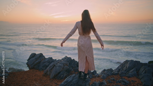 Dress lady watching evening marine nature back view. Woman touching hairstyle