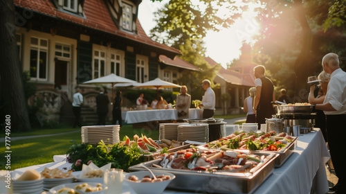 "Sunset Wedding Buffet" Outdoor wedding buffet near a historic building, bathed in the warm glow of the setting sun with staff attending to guests.