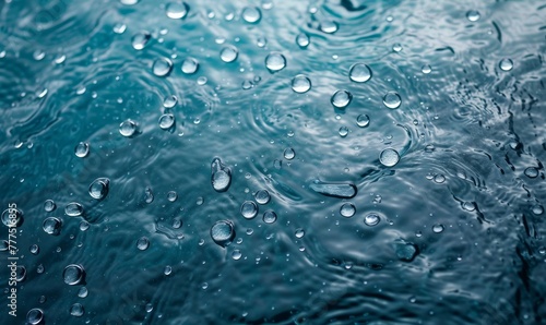   A tight shot of water droplets on a body of water s surface  against a backdrop of a clear blue sky