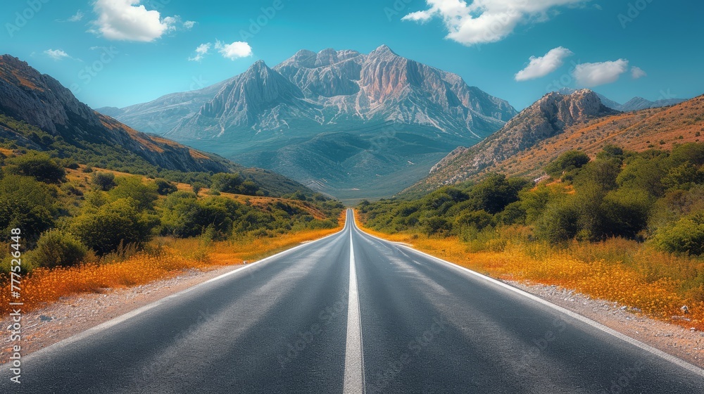 Naklejka premium A straight road, flanked by mountains in the foreground, leads to a distant mountain range