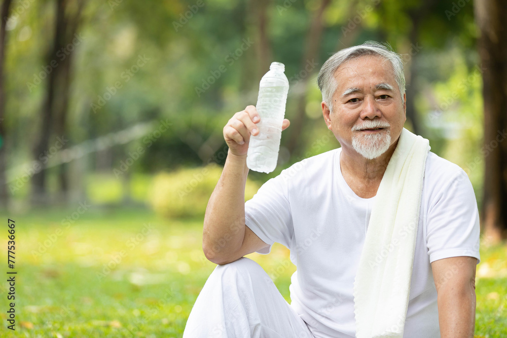 portrait senior man holding bottle of water in the park