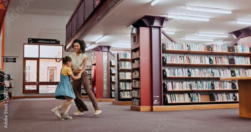 School, tutor or girl in a library dancing with smile for knowledge or development for future learning. Lady teacher, education or happy child student playing with parent, mother or woman on a break photo