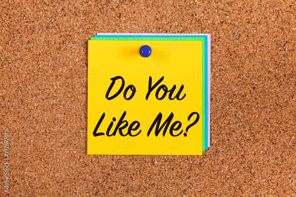 Yellow paper note with words Do You Like Me? on a cork board Yellow paper note with words Do You Like Me? on a cork board