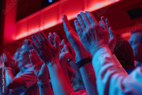 Close up photo of people clapping hands in a theatre 