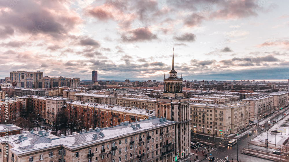 The warm hues of dusk settle over a snow-dusted cityscape St. Petersburg, with historic architecture standing prominently against a dramatic sky. Moskovsky Prospekt in St. Petersburg.