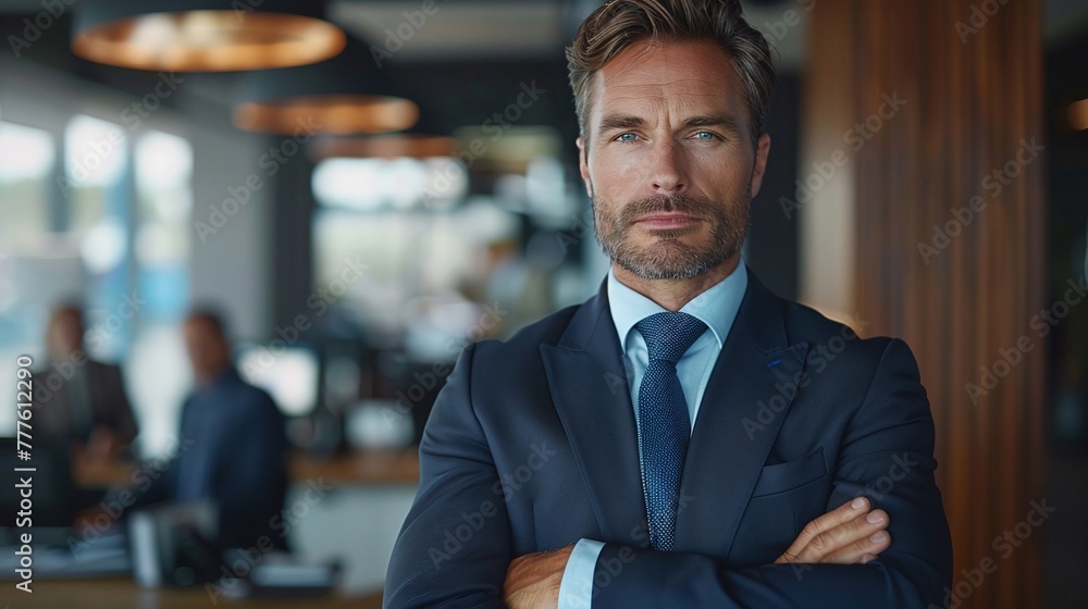 corporate teamwork: handsome business leader with crossed arms in office setting corporate teamwork: handsome business leader with crossed arms in office setting