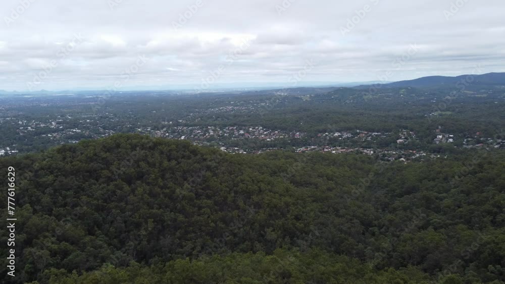Drone flying over thick green bushland towards a residential suburb in Australia Drone flying over thick green bushland towards a residential suburb in Australia
