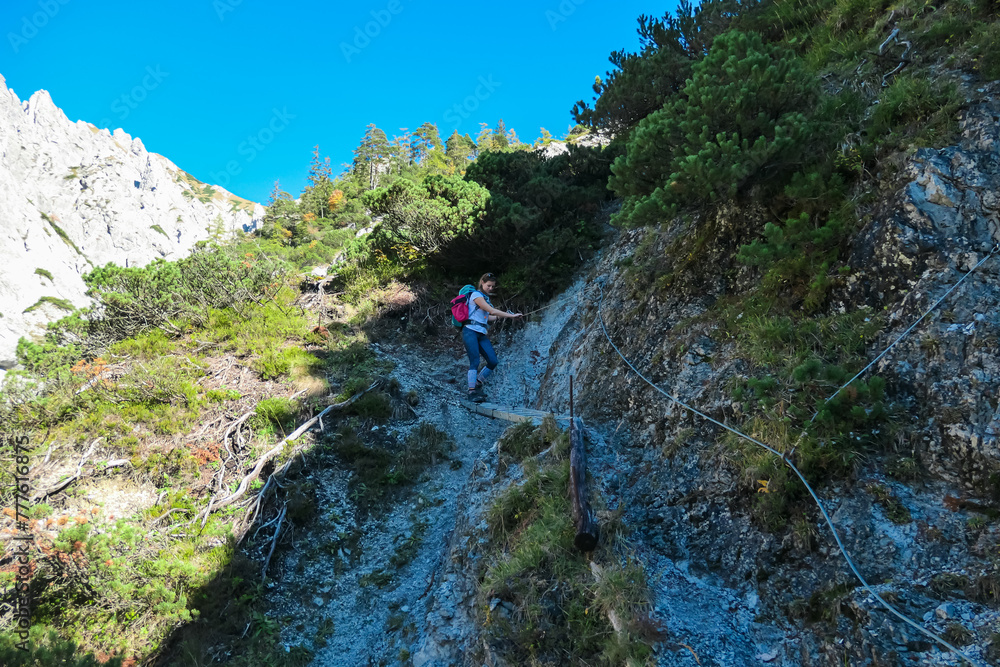 Hiker woman with panoramic view of mountain ridges in Hochschwab massif, Styria, Austria. Scenic via ferrata hiking trail along unique rock formations. Wanderlust in remote Austrian Alps in summer Hiker woman with panoramic view of mountain ridges in Hochschwab massif, Styria, Austria. Scenic via ferrata hiking trail along unique rock formations. Wanderlust in remote Austrian Alps in summer