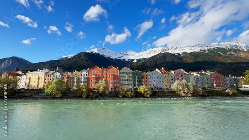 Innsbruck Austria colorful pastel buildings capital Tyrol Tyrolean Alps mountain backdrop the bridge over the Inn River Innbrücke clear blue sky clouds October November autumn fall wide static shot photo