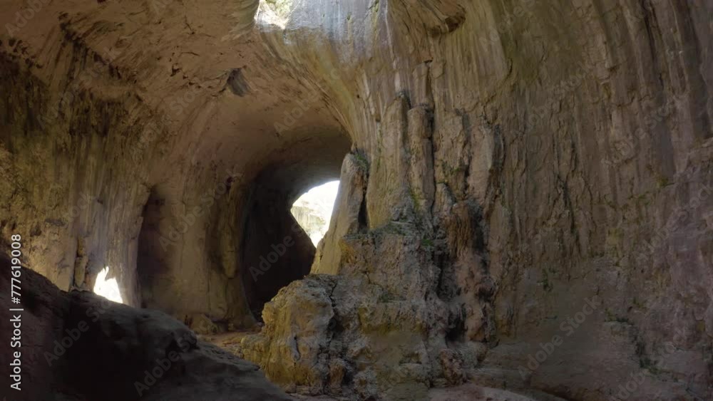 Follow through shot of the tunnels going to the chambers of Prohodna Cave, passing by limestone walls and stalagmites where holes known as God's Eyes can be seen in Karlukovo, in Bulgaria. Follow through shot of the tunnels going to the chambers of Prohodna Cave, passing by limestone walls and stalagmites where holes known as God's Eyes can be seen in Karlukovo, in Bulgaria.
