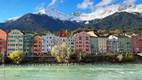 Innsbruck Austria colorful pastel buildings capital Tyrol Tyrolean Alps mountain backdrop the bridge over the Inn River Innbrücke clear blue sky clouds October November autumn fall sunny static shot photo