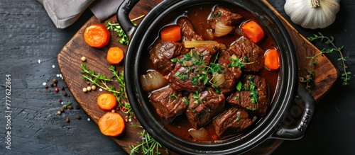 A pot filled with German-style braised beef cheeks in a rich red wine sauce, accompanied by tender carrots and onions simmering to perfection. photo