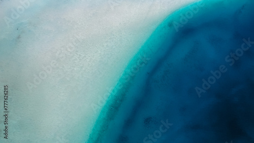 Abstract of sandy shallow water transitioning to deep blue water