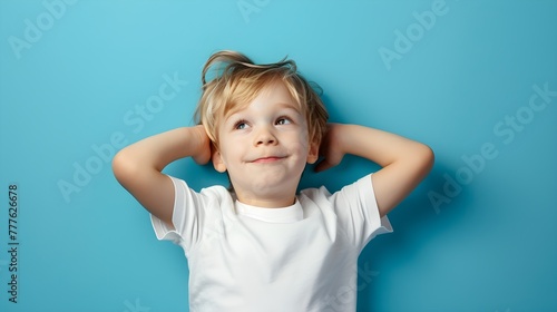 A close-up portrait of a cute little boy smiling brightly in studio background