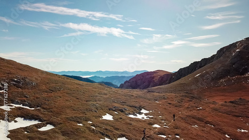 Aerial view of hiker couple on idyllic hiking trail on alpine meadow in majestic Hochschwab mountain range, Styria, Austria. Wanderlust in remote Austrian Alps. Sense of escapism, peace, reflection photo