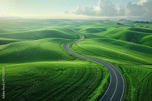 Aerial view of highway winding through lush wheat fields.