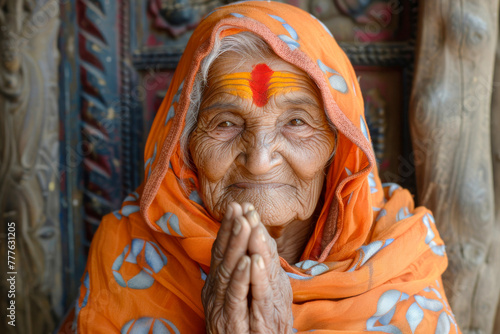 An elderly woman adorned in vibrant traditional attire displays her rich cultural heritage and the wisdom of age with a compelling