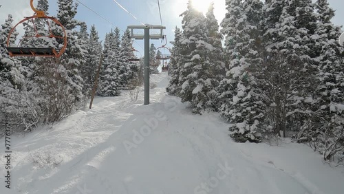 Skiing and snowboarding ski resort background. Chairlift and winter panorama at ski resort. View on the ski lift and beautiful snowy mountain with pine trees. The ski resort Karakol, Kyrgyzstan. photo