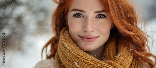A joyful European woman with vibrant red hair is wearing a stylish scarf around her neck.