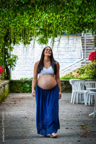 Beautiful Latina girl in the last months of pregnancy with long black hair walking and smiling