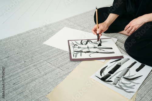 Unrecognizable Female Creating Drawings in Japanese technique. photo
