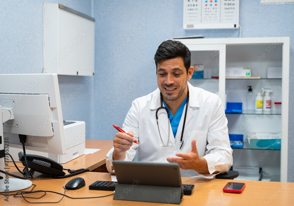 doctor using a tablet computer in his office doing a videocall doctor using a tablet computer in his office doing a videocall