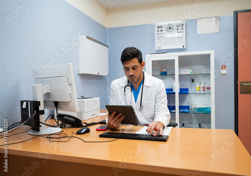 doctor using a tablet computer in a medical office photo